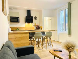 a living room with a couch and a kitchen at Chez le Padré in Olivet