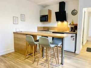 a kitchen with a wooden counter top and chairs at Chez le Padré in Olivet +28 photos