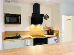 a kitchen with a sink and a microwave at Chez le Padré in Olivet