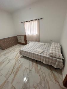 a bedroom with a bed and a tiled floor at CONDOMINIO JT ll in Ubatuba