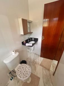 a bathroom with a toilet and a sink at CONDOMINIO JT ll in Ubatuba
