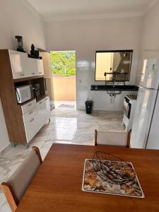 a living room with a table and a kitchen at CONDOMINIO JT ll in Ubatuba