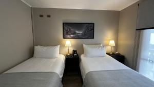 two beds in a hotel room with two lamps at Hotel Nevados de Chillan in Nevados de Chillan +77 photos