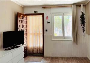 a living room with a television and a window at Muy bien in San Javier