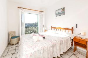 a bedroom with a bed and a desk and a window at VILLA NUEVA II in Cala Galdana