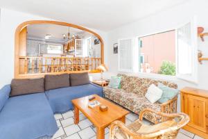 a living room with a blue couch and a table at VILLA NUEVA II in Cala Galdana