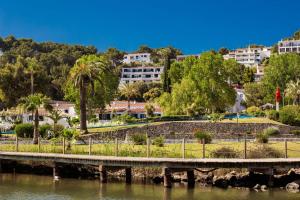a bridge over a river with buildings in the background at VILLA NUEVA II in Cala Galdana