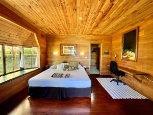 a bedroom with a bed in a wooden room at Fare Hotu Villa plus voiture-car in Fitii