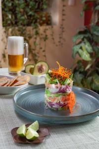 a sandwich on a blue plate with a glass of beer at Hotel Plaza San Carlos in Xicotepec de Juárez