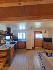 a large kitchen with wooden floors and a white refrigerator at Alba Odeceixe - casa clara in Odeceixe