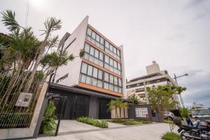 a building with palm trees in front of it at Jurerê Sol&Mar Temporada in Florianópolis