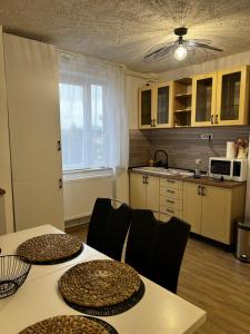 a kitchen with two tables and chairs and a kitchen with a window at Apartament Atrium Gara Afi in Arad +8 photos
