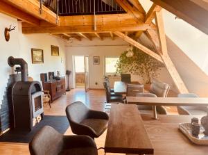 a living room with a wood stove and chairs at Badischhaus am Waldrand & Weitblick in Herrischried