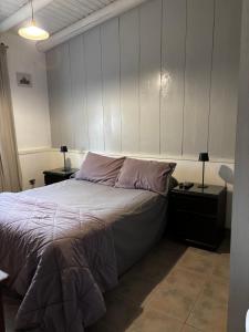 a bedroom with a large bed with two tables and two lamps at PataGo! Sea&Sand in Playa Unión