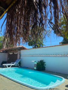 a swimming pool in front of a house at Hostel Itaparica Casa in Itaparica