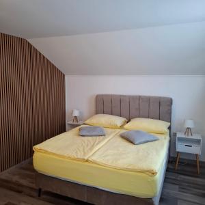 a bedroom with a large bed with two pillows on it at Guesthouse Sara in Grabovac +65 photos