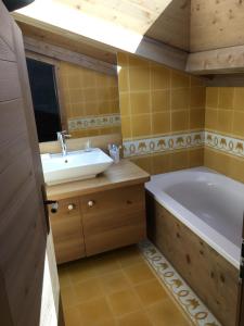 a bathroom with a tub and a sink at Chalet Mine de rien in Megève