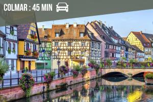 a city with a bridge and buildings next to a river at La Ferme des 3 lacs in Xonrupt-Longemer +28 photos