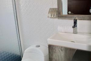a bathroom with a white toilet and a sink at Hotel ESTRELLA in Zacatlán