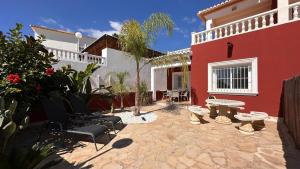a courtyard of a red and white house with a table and chairs at Casa Amis Calpe in Calpe