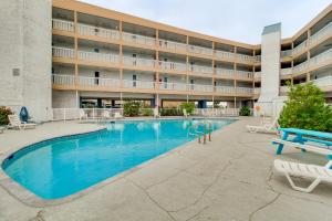a swimming pool in front of a building at Steps to North Beach: Gem w/ Ocean-View Balcony! in Corpus Christi +17 photos