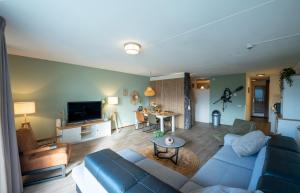 a living room with a couch and a table at Beach Apartment By The Sea in Julianadorp