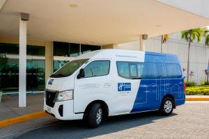 a white and blue van parked in front of a building at Holiday Inn Express Manzanillo by IHG in Manzanillo