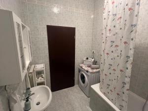 a bathroom with a sink and a washing machine at Apartment Vesna in Veleniki +62 photos