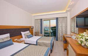 a hotel room with two beds and a television at İncekum West Hotel -Ultra All Inclusive in Alanya +57 photos