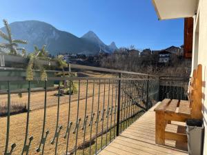 a balcony with a bench and mountains in the background at Tra prati e monti - Dolomiti Bellunesi in Valle di Cadore