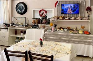 a dining room with two tables and a tv at Pousada Folhas de Outono in Canela