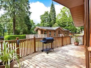 a deck with a wooden fence and a chair on it at Beech Hill Lodge Beech Hill 9 at Fallbarrow Park in Windermere