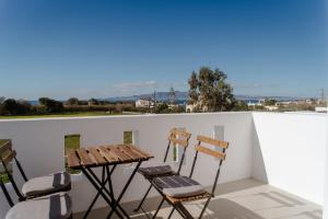 a table and chairs on a balcony with a view at Aelia Kastraki Beach House in Kastraki