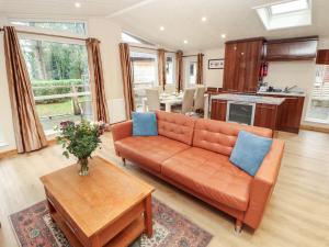 a living room with an orange couch and a table at Beech Hill Lodge Beech Hill 9 at Fallbarrow Park in Windermere