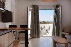 a kitchen with a table and a view of a patio at Aelia Kastraki Beach House in Kastraki