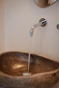a stream of water pouring into a copper sink at Aelia Kastraki Beach House in Kastraki