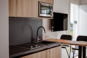 a kitchen with a black sink and a table at Aelia Kastraki Beach House in Kastraki +19 photos