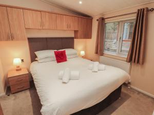 a bedroom with a large white bed with two pillows at Beech Hill Lodge Beech Hill 9 at Fallbarrow Park in Windermere
