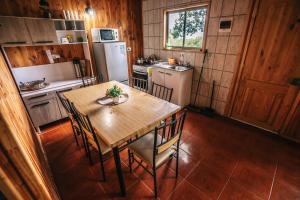 a kitchen with a table and chairs and a refrigerator at Cabañas Ruta Volcán Pucon in Pucón