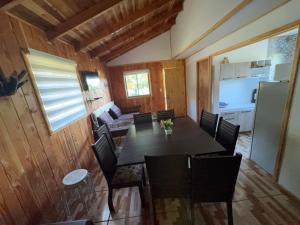 a dining room with a table and chairs at Cabañas Ruta Volcán Pucon in Pucón +10 photos
