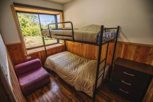 a bedroom with two bunk beds and a window at Cabañas Ruta Volcán Pucon in Pucón
