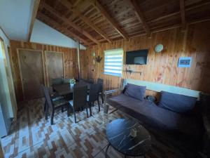 a living room with a couch and a dining table at Cabañas Ruta Volcán Pucon in Pucón