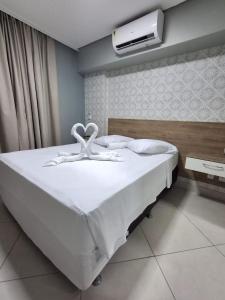a bedroom with a bed with white sheets and towels at Apart 203 Vista Mar in Fortaleza