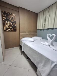 two swans sitting on a bed in a room at Apart 203 Vista Mar in Fortaleza