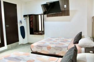 a bedroom with a bed and a tv on the wall at Hotel ESTRELLA in Zacatlán