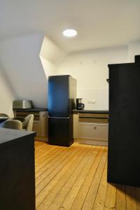 a kitchen with a refrigerator in the middle of a room at Altstadt Apartment Deluxe 3 in Haltern +8 photos