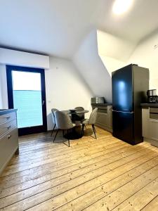 a kitchen with a refrigerator and a table and chairs at Altstadt Apartment Deluxe 3 in Haltern
