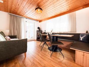 a living room with a table and a couch at 1210 Apartments Benglerwald in Bach