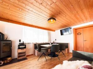a living room with a table and chairs and a television at 1210 Apartments Benglerwald in Bach