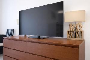 a flat screen tv sitting on top of a dresser at FRAME by Tendo Stay - Comfort Housing in Falkensee